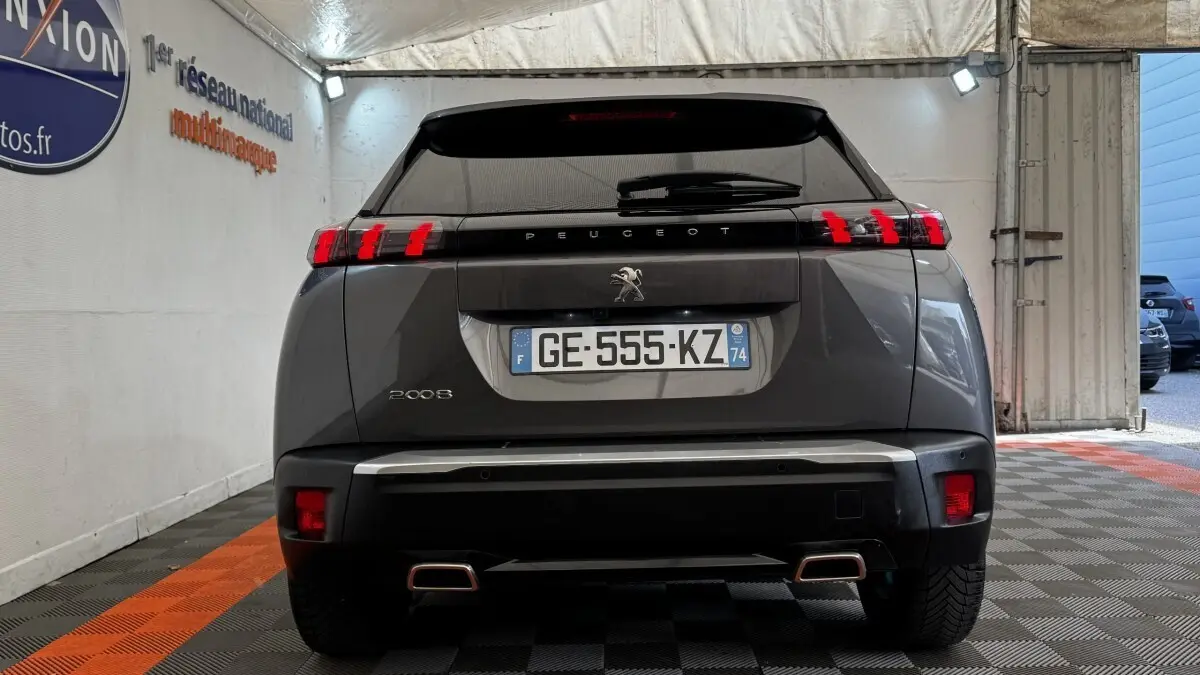 Vue arrière d’un Peugeot 2008 gris foncé 2022 avec feux LED et double sortie d’échappement rectangulaire.