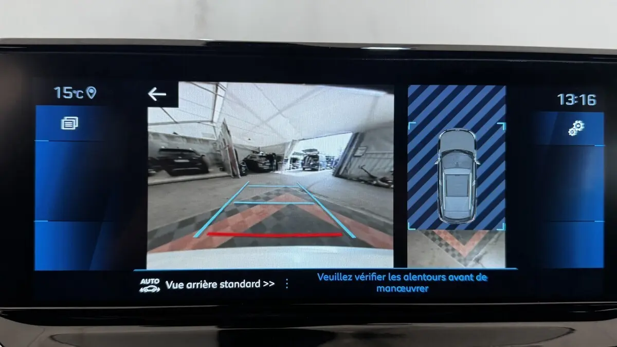 Écran tactile intérieur montrant la caméra de recul et l'affichage 3D du Peugeot 2008 gris foncé en stationnement.