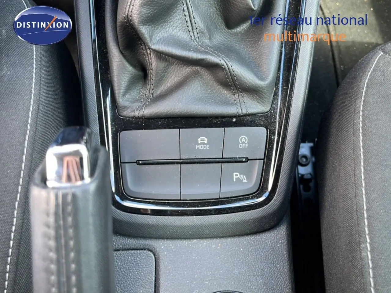 Gros plan sur la console centrale de la Skoda Scala gris magnétique, montrant la commande de boîte auto et les boutons de mode et parking.