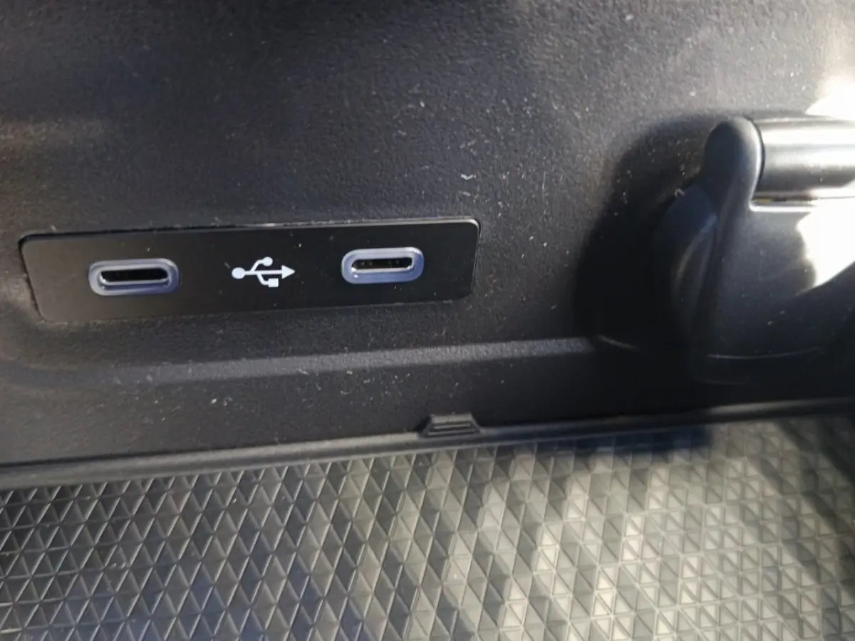 Gros plan sur deux ports USB-C et une prise 12V dans l'habitacle du Renault Austral blanc esprit Alpine.