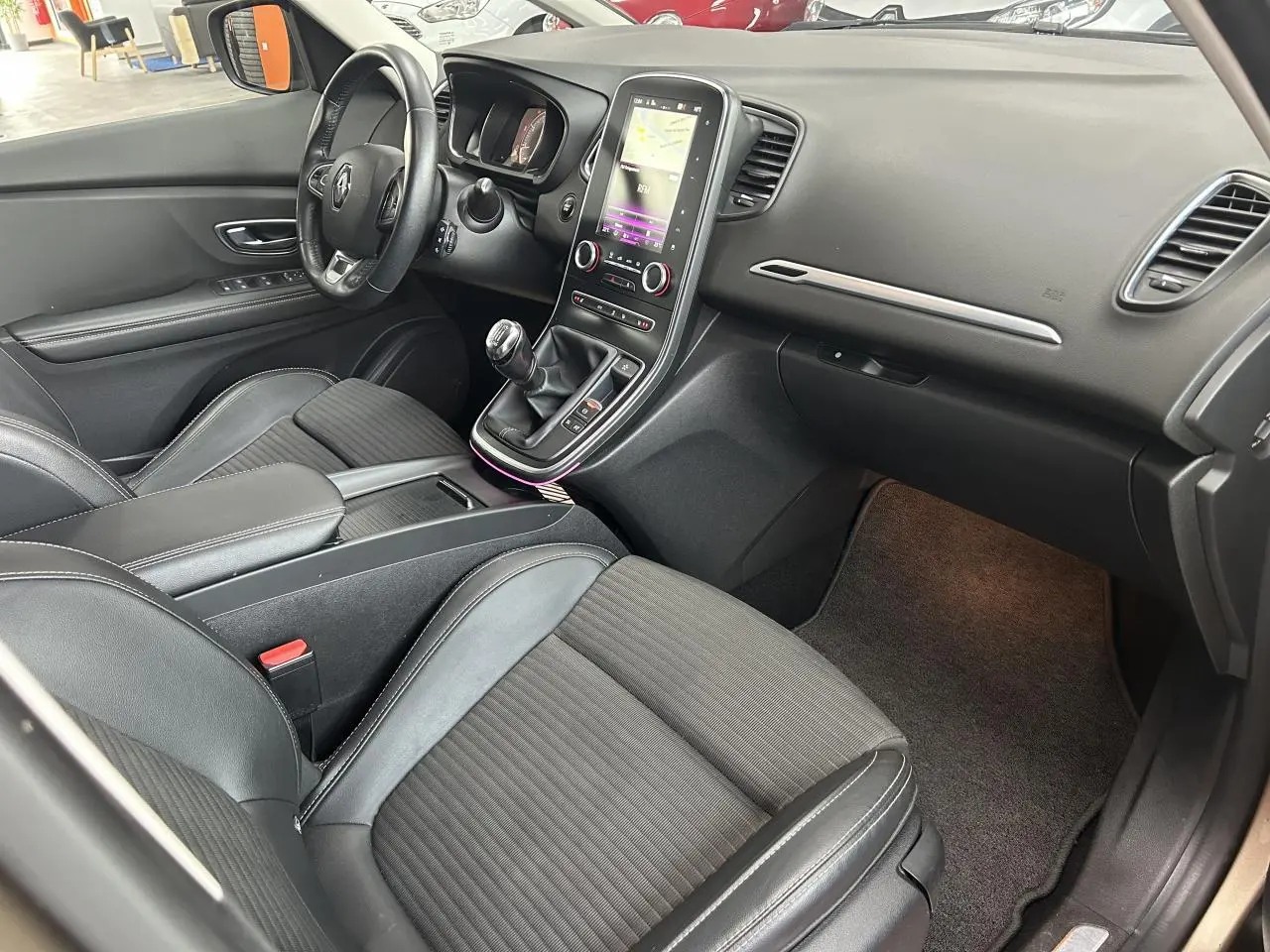 Intérieur côté conducteur du Renault Scénic Grand IV 2017, avec sellerie mixte noire et console centrale tactile verticale.