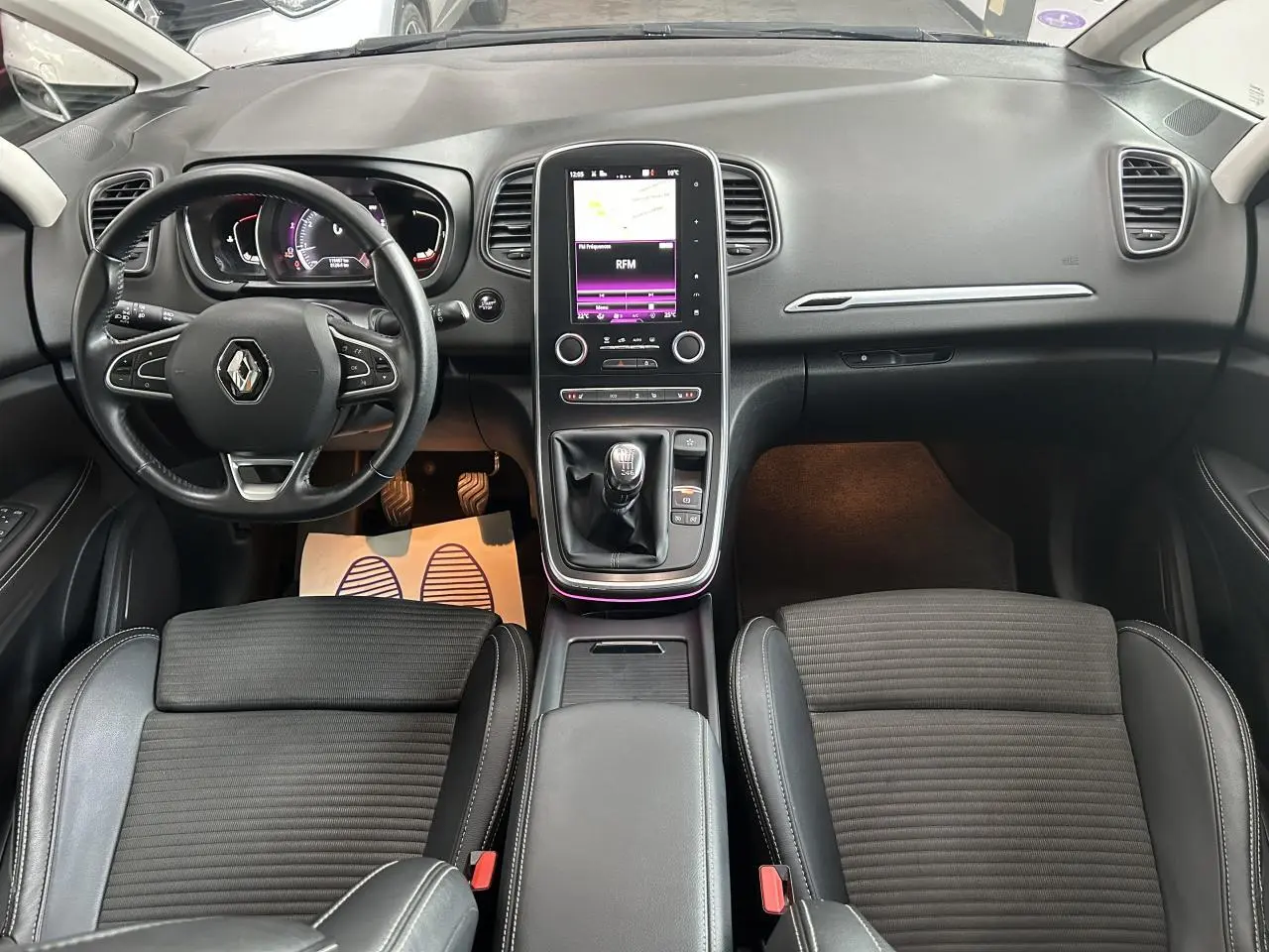 Intérieur Renault Scenic Grand IV vue de dessus, tableau de bord noir avec écran tactile vertical et levier de vitesses manuel.