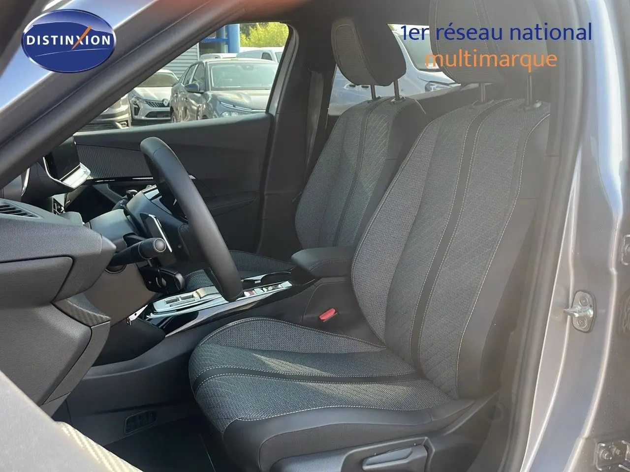 Vue intérieure côté conducteur du Peugeot 2008 Hybrid gris Artense, mettant en valeur les sièges tissu et cuir noir.