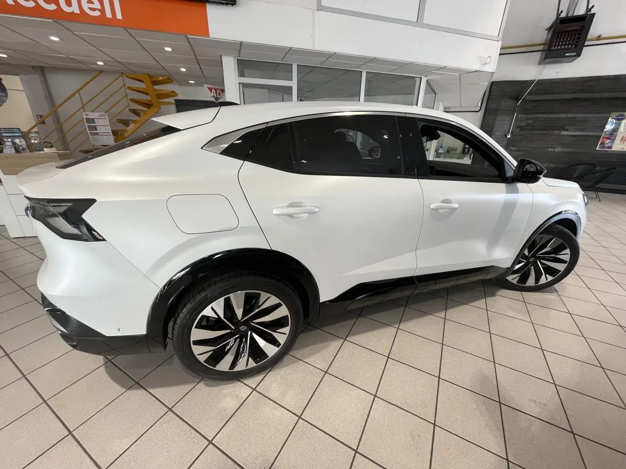 Vue latérale droite d'un Renault Rafale blanc 2025 avec jantes alliage noires et détails noirs contrastants.