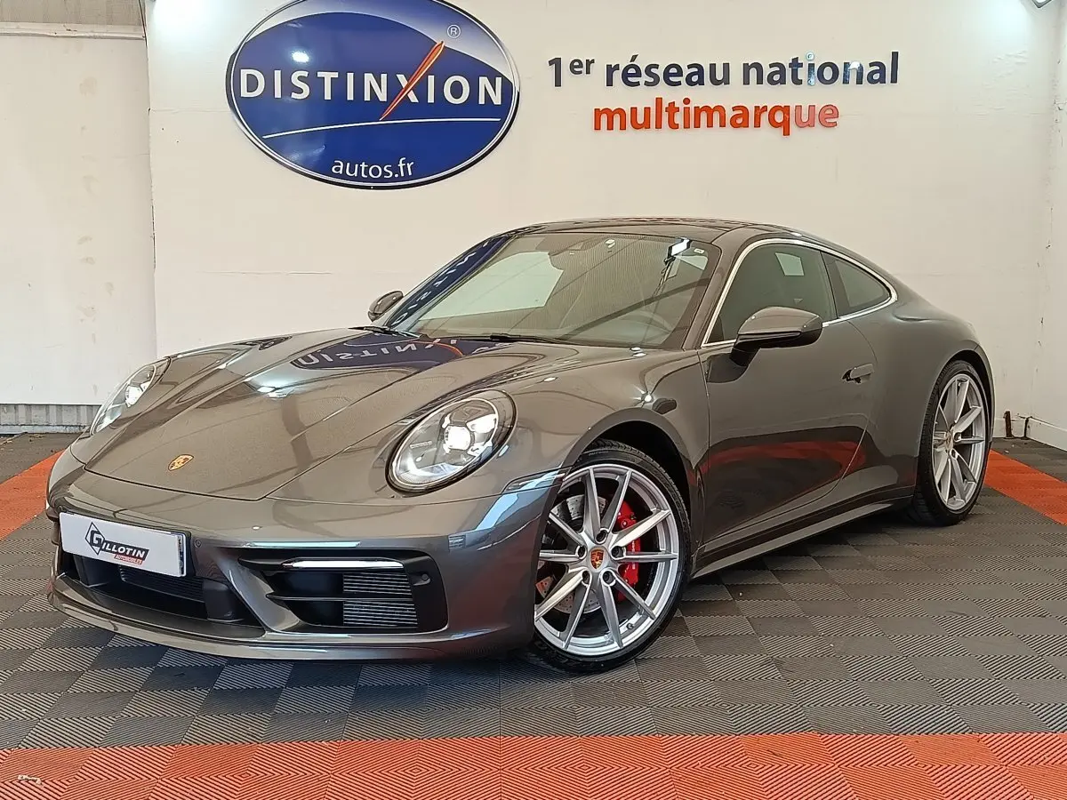 Vue 3/4 avant droite d'une Porsche 911 Carrera 4S Coupé gris foncé avec jantes alliage et étriers de frein rouges.