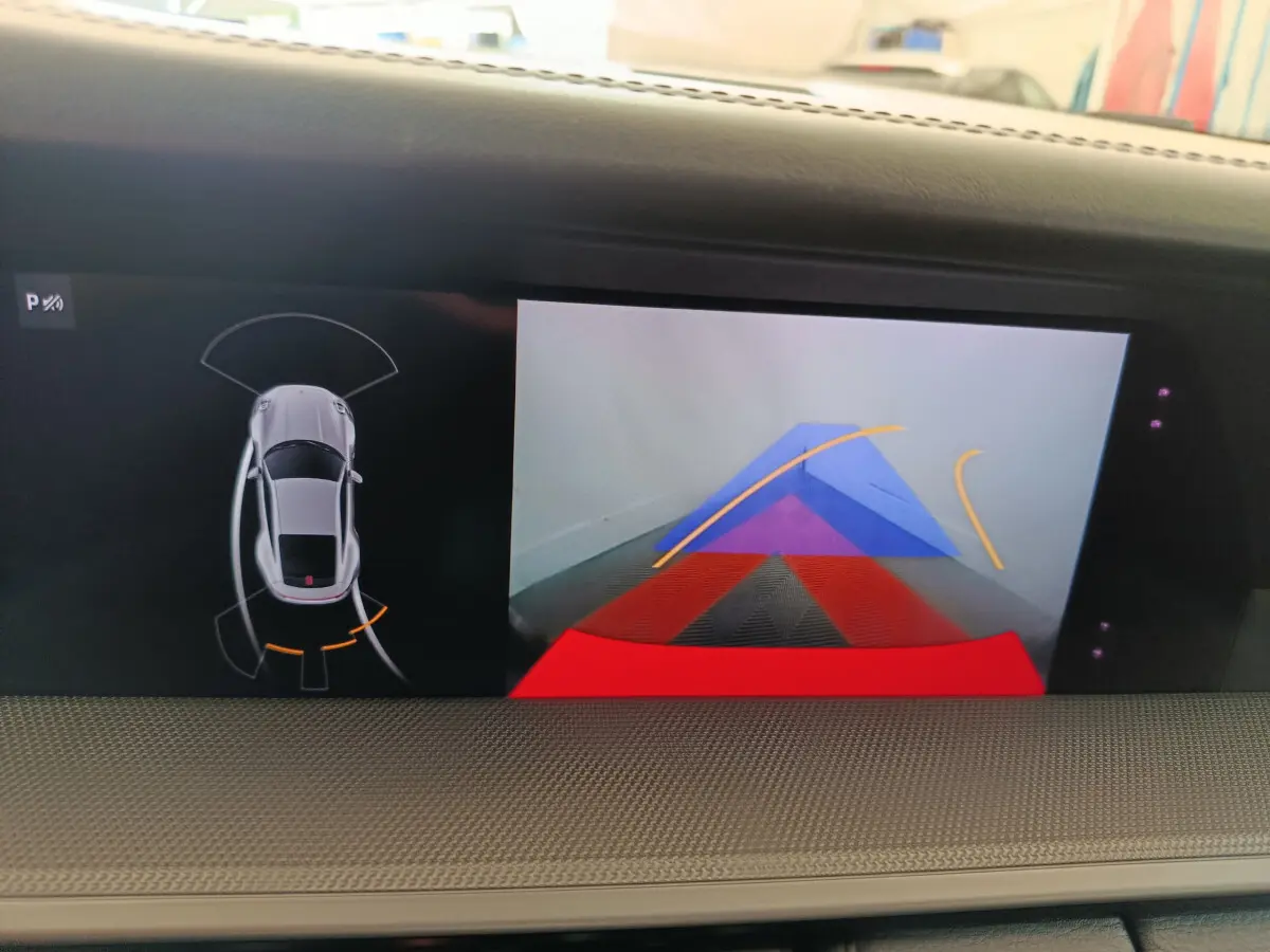 Écran tactile intérieur affichant la caméra de recul et le capteur de stationnement d'une Porsche 911 gris foncé.