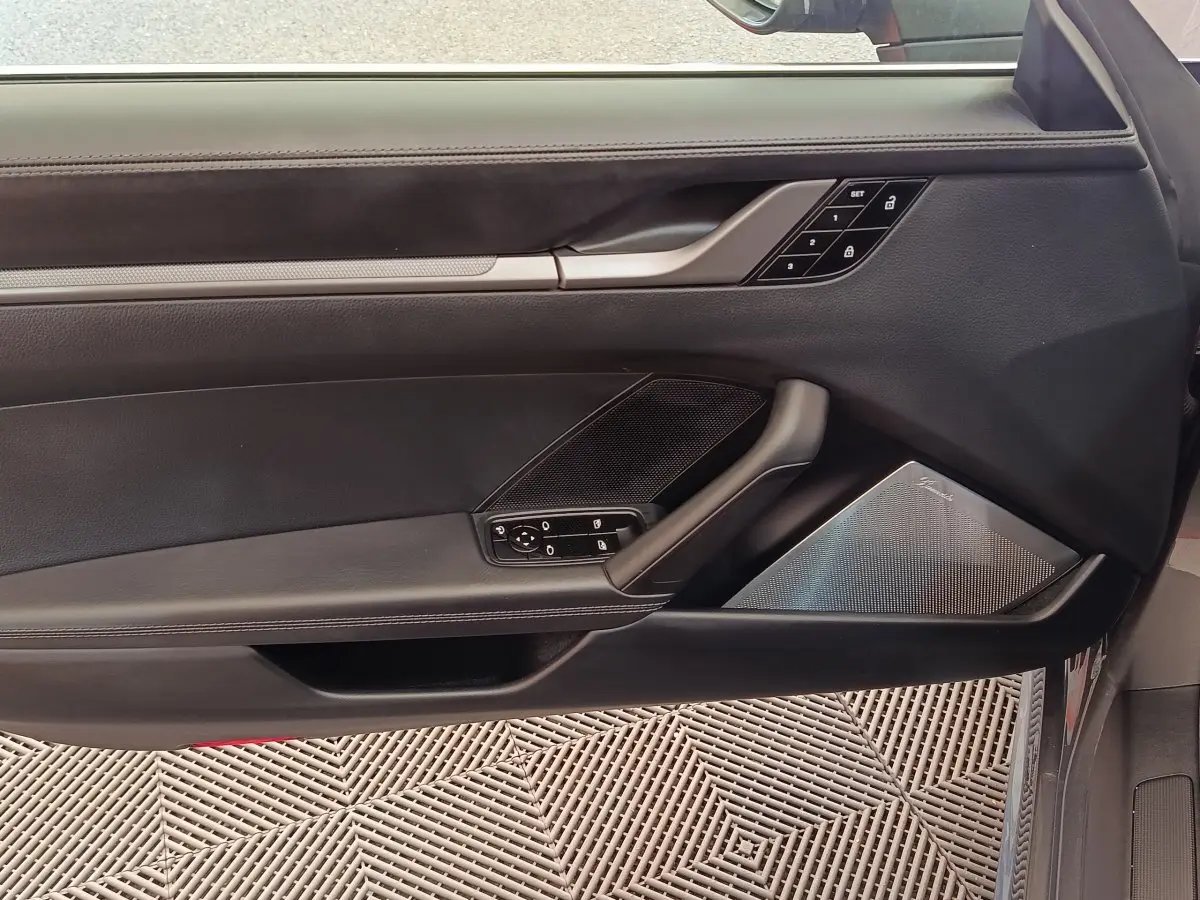 Vue intérieure de la porte côté conducteur d'une Porsche 911 Carrera 4S 2019, garniture cuir noir et haut-parleur Burmester.