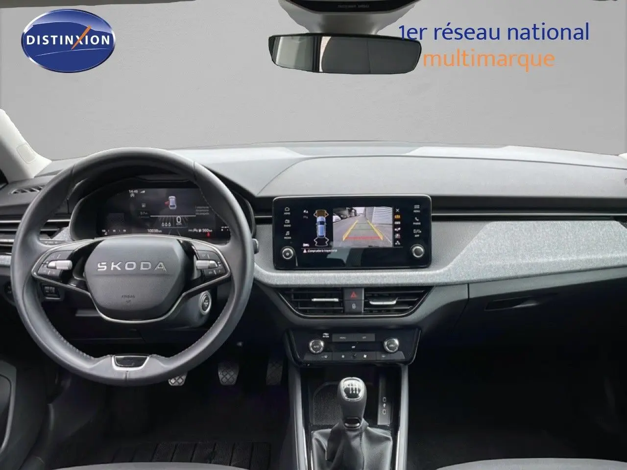 Vue intérieure avant du Skoda Scala 2025 noir magique métal, avec tableau de bord numérique et écran central affichant la caméra de recul.