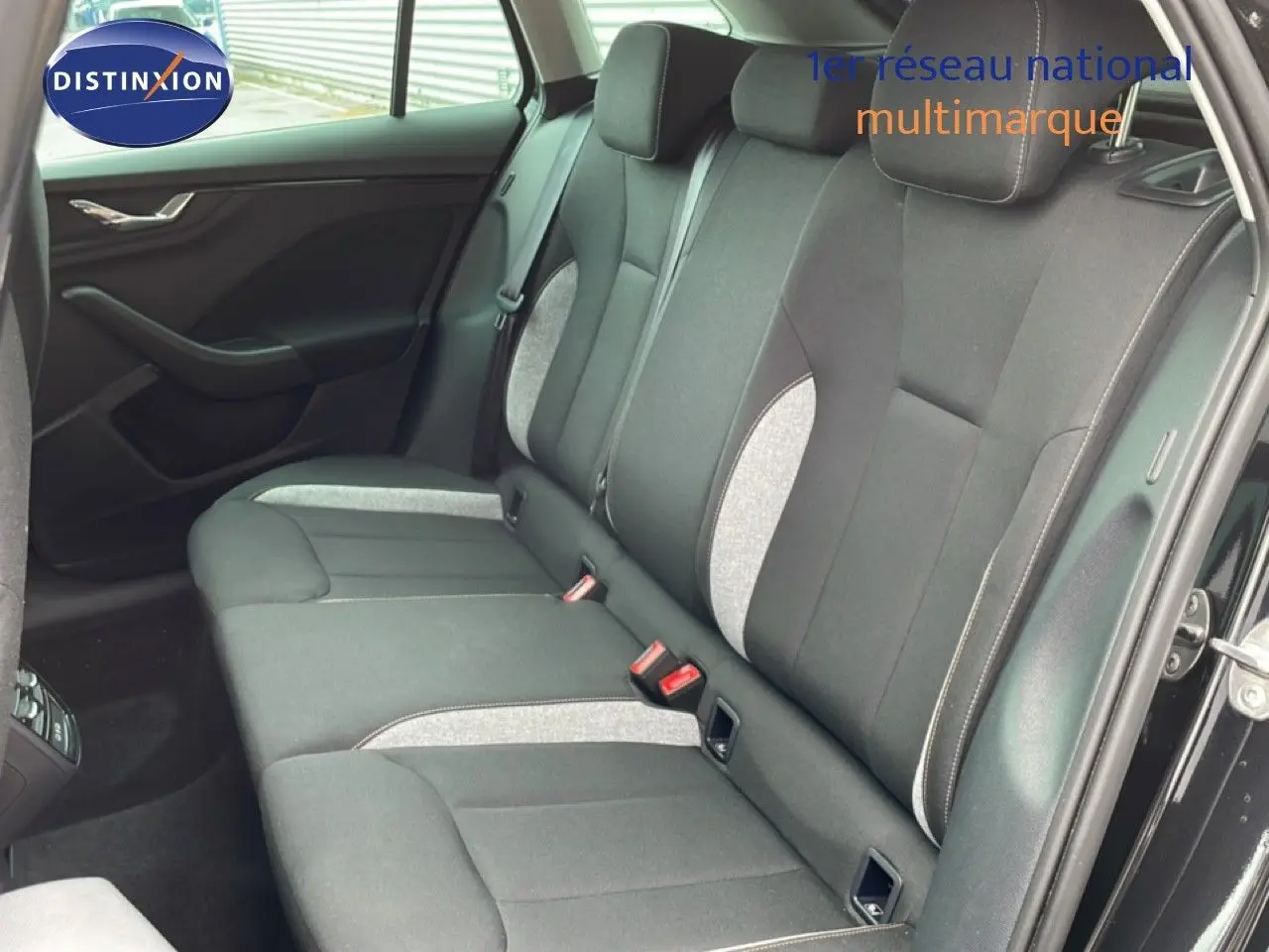 Vue intérieure côté droit montrant la banquette arrière en tissu gris et noir d'une Skoda Scala noir magique métal.