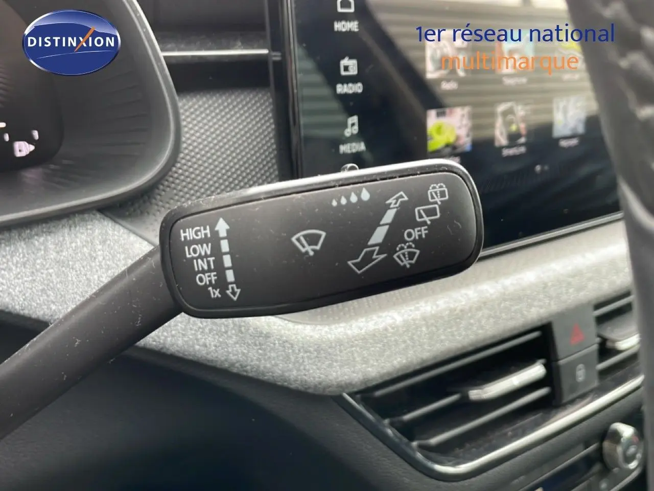 Gros plan sur la commande d’essuie-glace à gauche du volant dans l’habitacle gris noir d’une Skoda Scala noir magique métal.