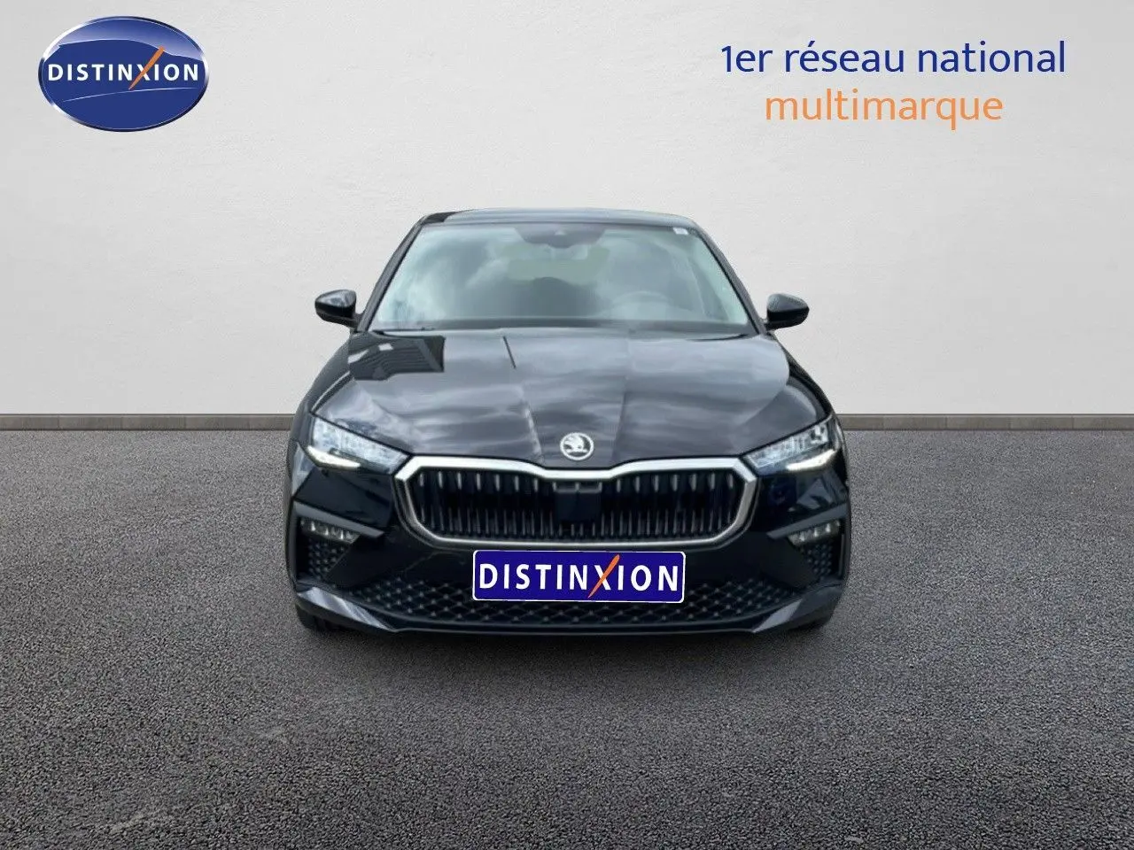 Vue frontale d'une Skoda Scala noire métallisée, mettant en valeur sa calandre distinctive et ses phares LED fins.