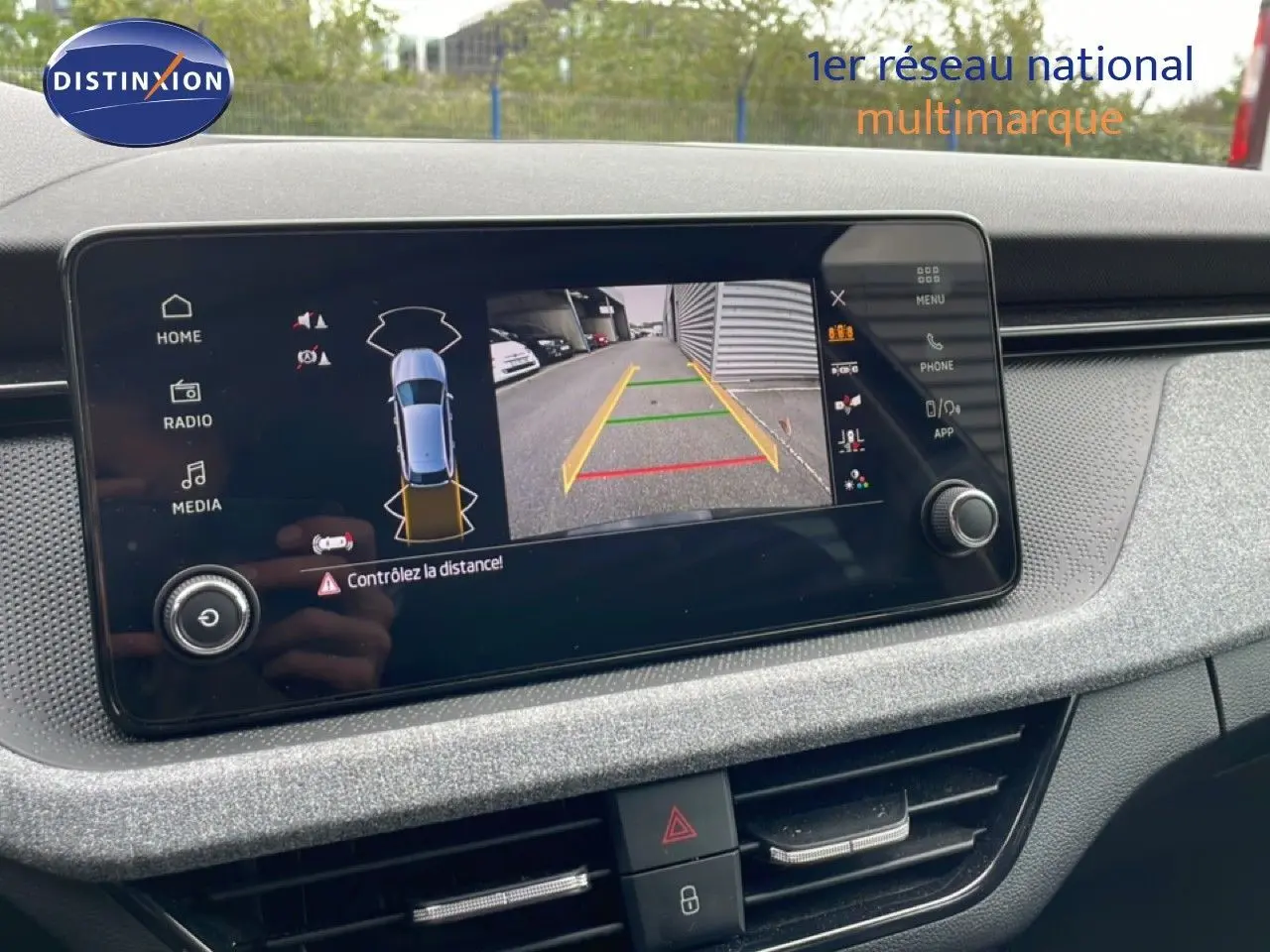 Écran central de la Skoda Scala 2025 montrant la caméra de recul avec guidage de trajectoire, tableau de bord gris clair.