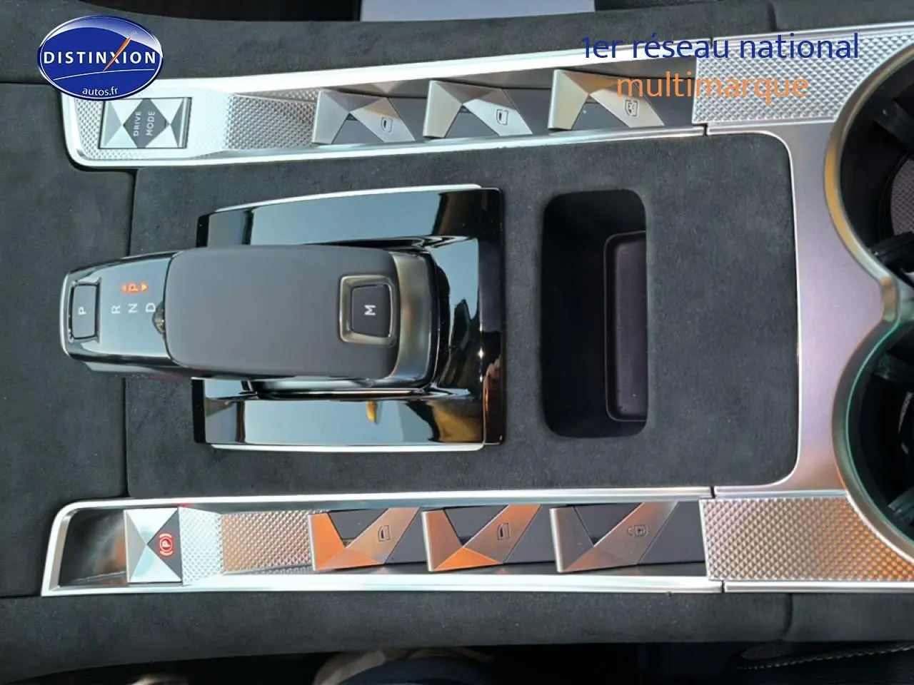 Vue rapprochée de la console centrale noire du DS7 1.5 BlueHDi 130 avec levier de vitesse automatique et boutons triangulaires chromés.