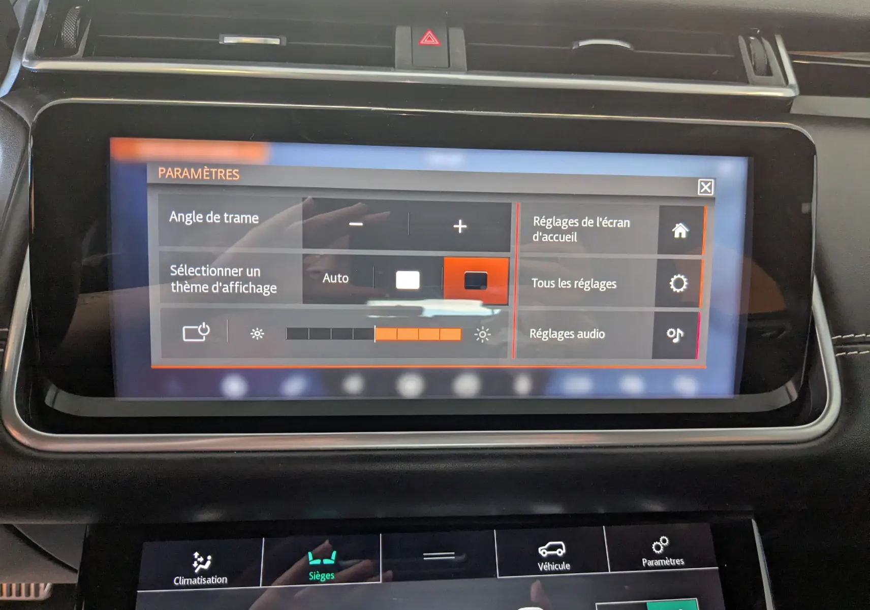 Écran tactile central du tableau de bord du Range Rover Velar noir, affichant les réglages des paramètres.