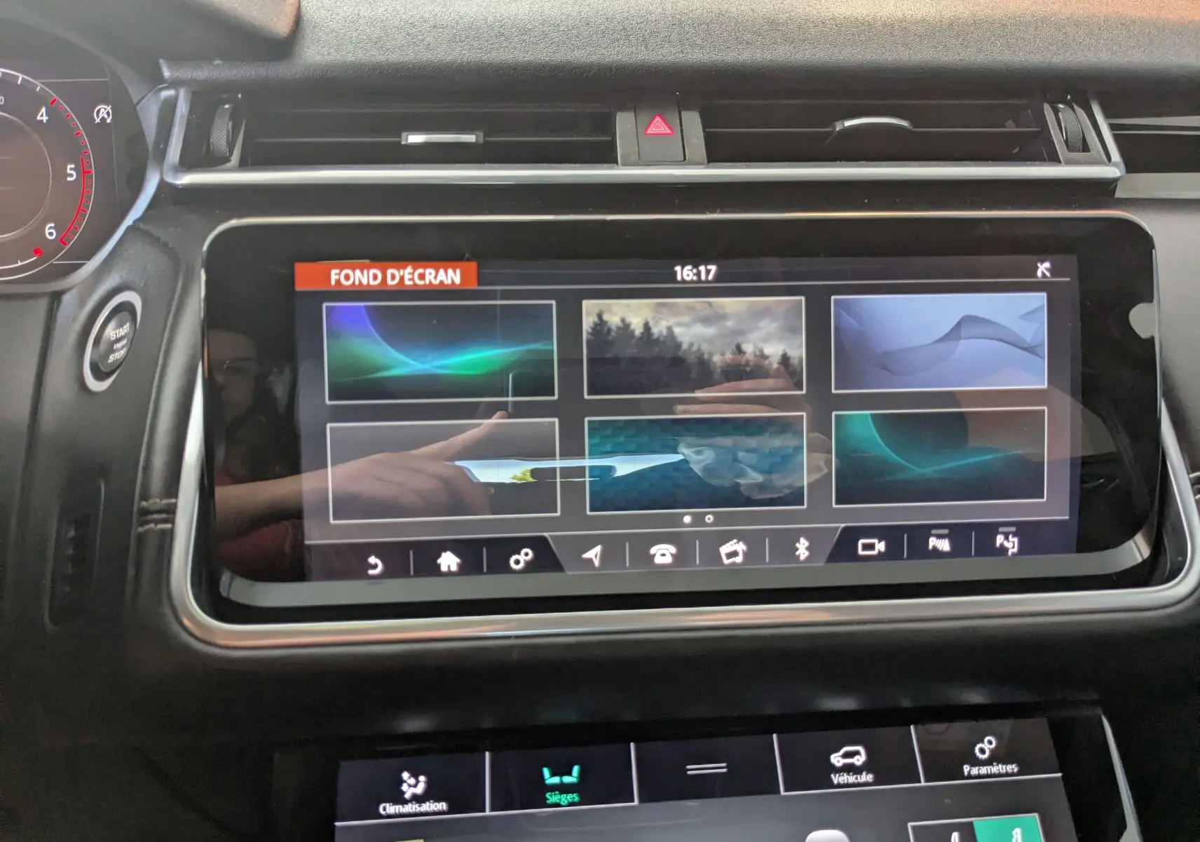 Écran tactile central du tableau de bord du Range Rover Velar noir 2020, affichant les options de fond d'écran.