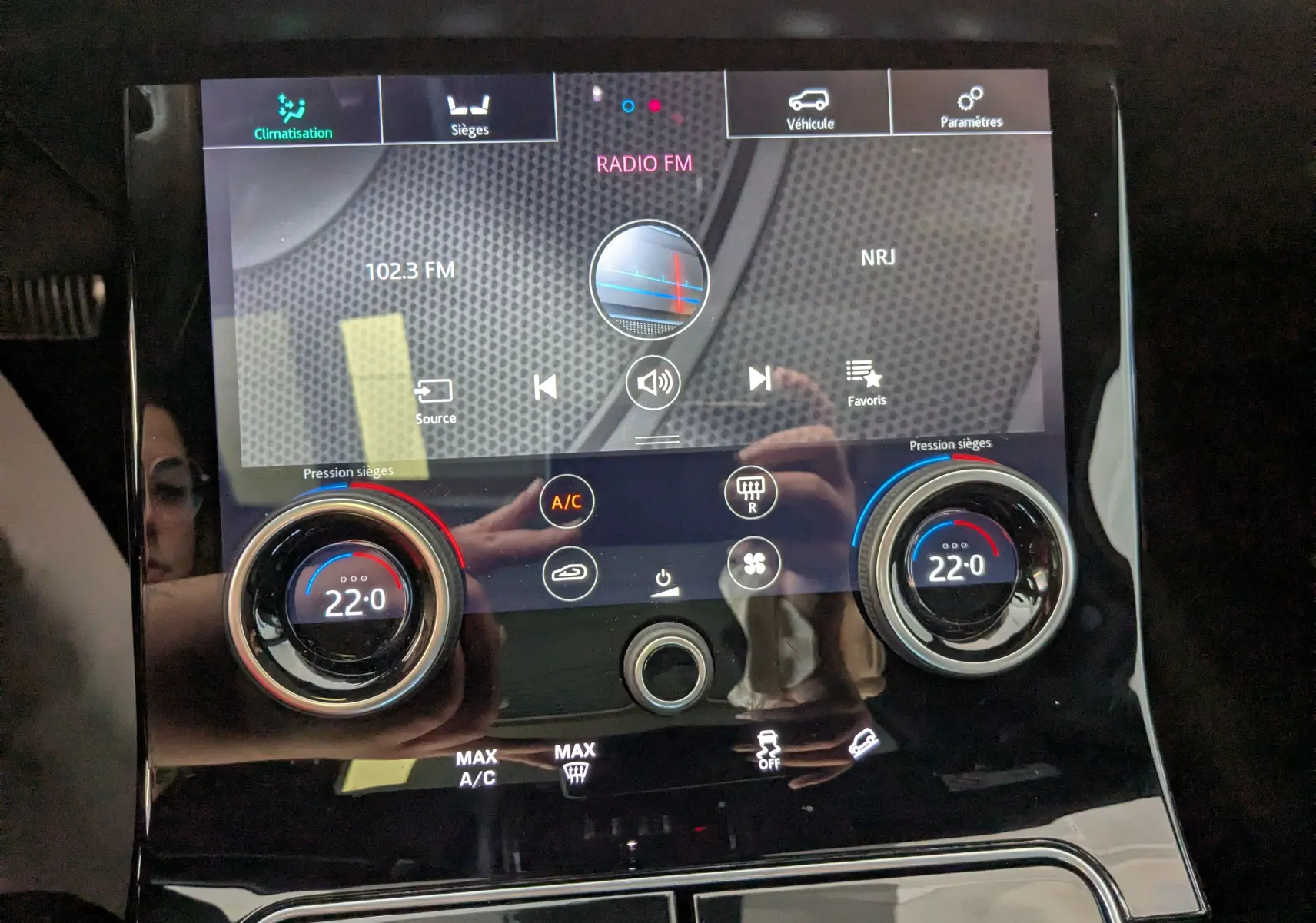 Écran tactile central du Range Rover Velar noir 2020 montrant la radio FM et les réglages de climatisation à 22°C.