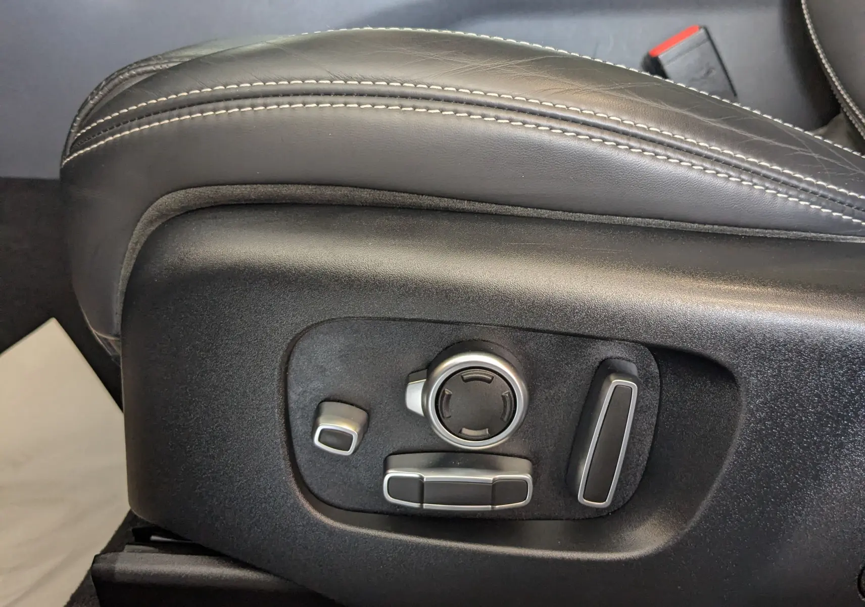 Réglages électriques en gros plan sur le côté gauche du siège en cuir noir du Range Rover Velar 2020.