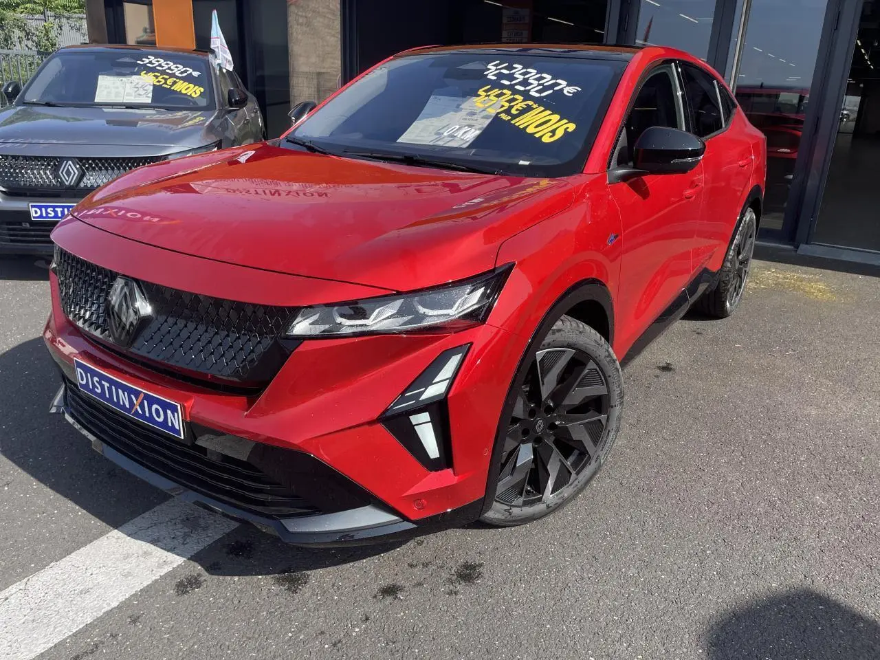 Renault Rafale rouge à toit noir en 3/4 avant droit, avec calandre noire et jantes alliage noires distinctives.