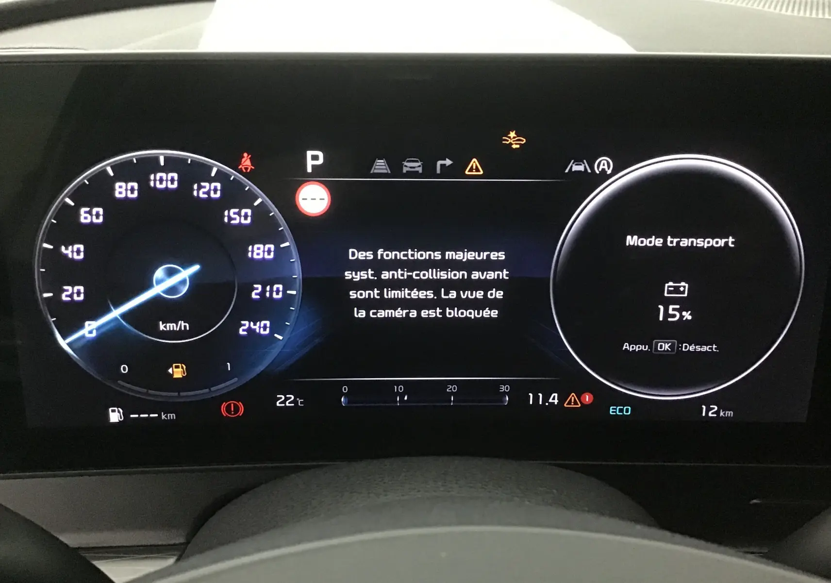 Combiné d'instrumentation digital 12,3'' du Kia Sportage blanc 2025 affichant mode transport et alertes système.