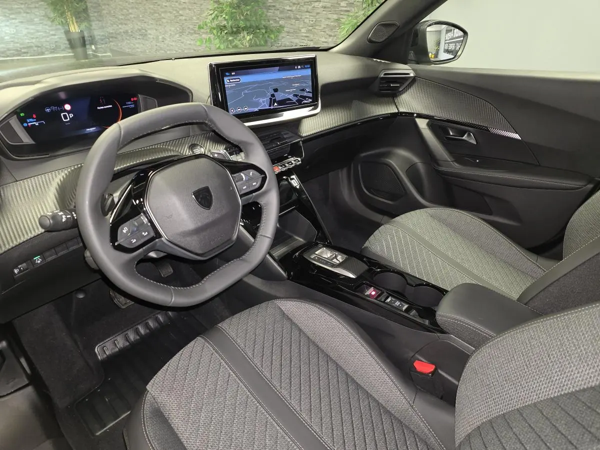 Vue intérieure avant droite du Peugeot 2008 2025 gris, avec tableau de bord numérique et écran tactile central.