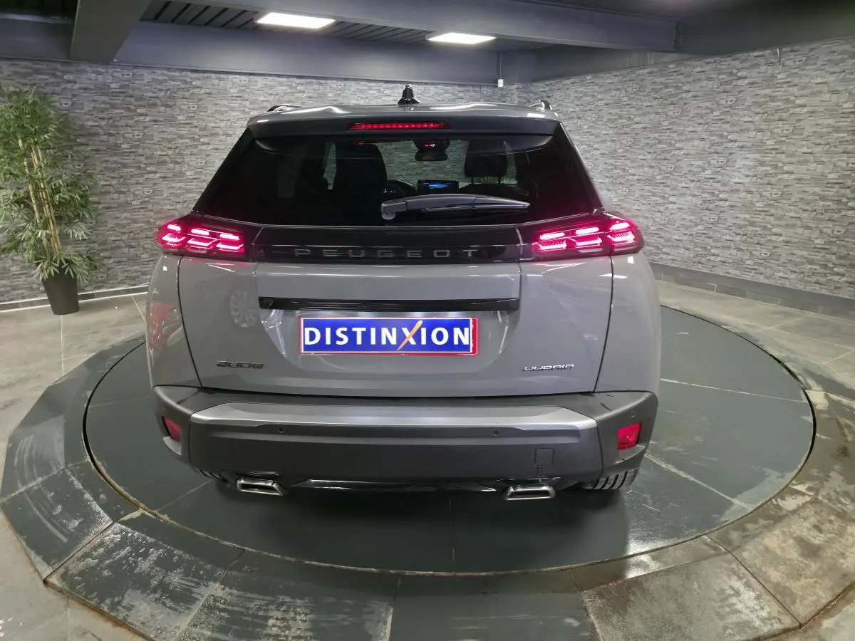 Vue arrière d'un Peugeot 2008 gris 2025 avec feux arrière LED 3 griffes et double canule d'échappement chromée.