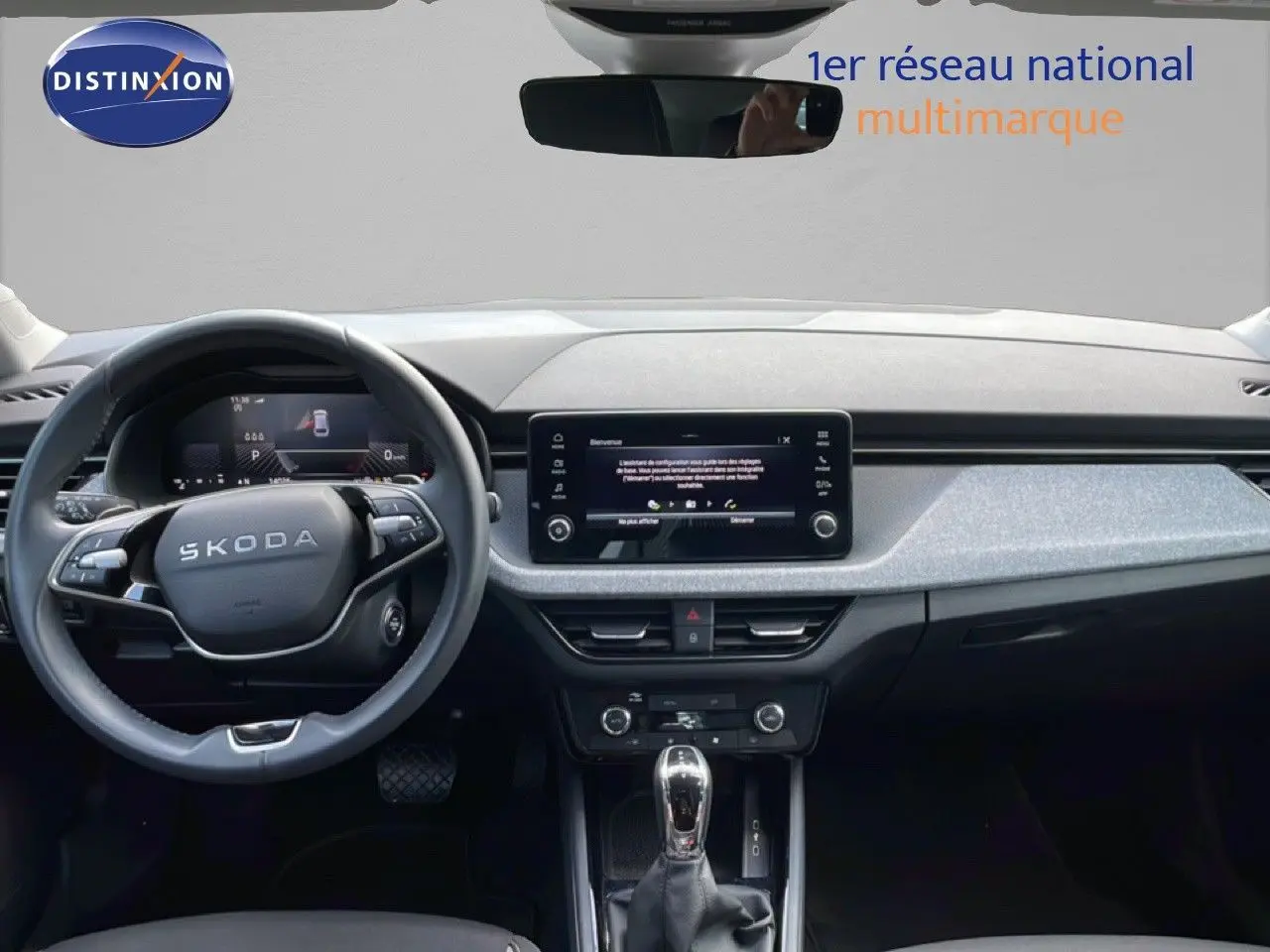 Vue intérieure frontale du tableau de bord de la Skoda Scala blanc glacier, avec écran tactile et volant multifonction.