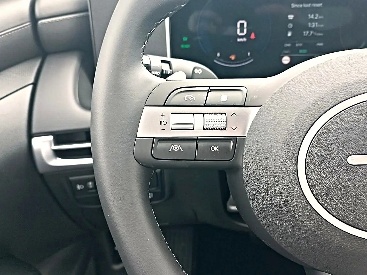 Gros plan sur le volant cuir multifonction gris du Hyundai Tucson 2026 avec commandes intégrées et tableau de bord digital.