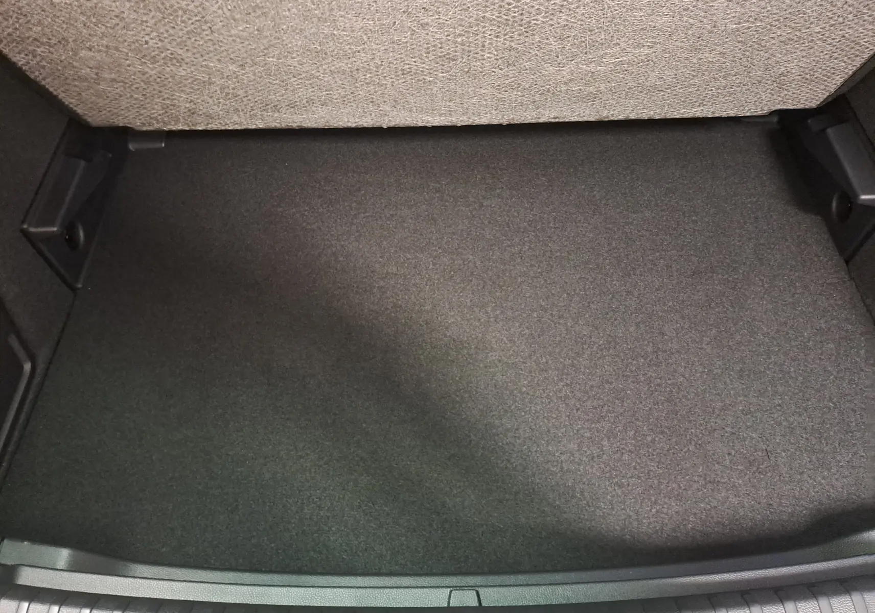 Vue rapprochée du plancher de chargement variable du coffre du Skoda Karoq blanc lune, sans chargement visible.