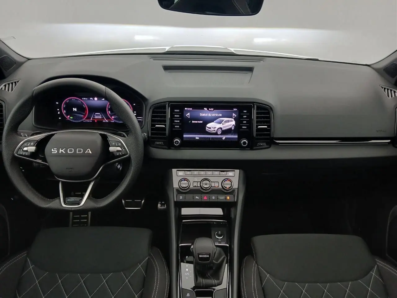 Vue intérieure frontale du tableau de bord et volant SKODA KAROQ avec écran tactile et commandes numériques.