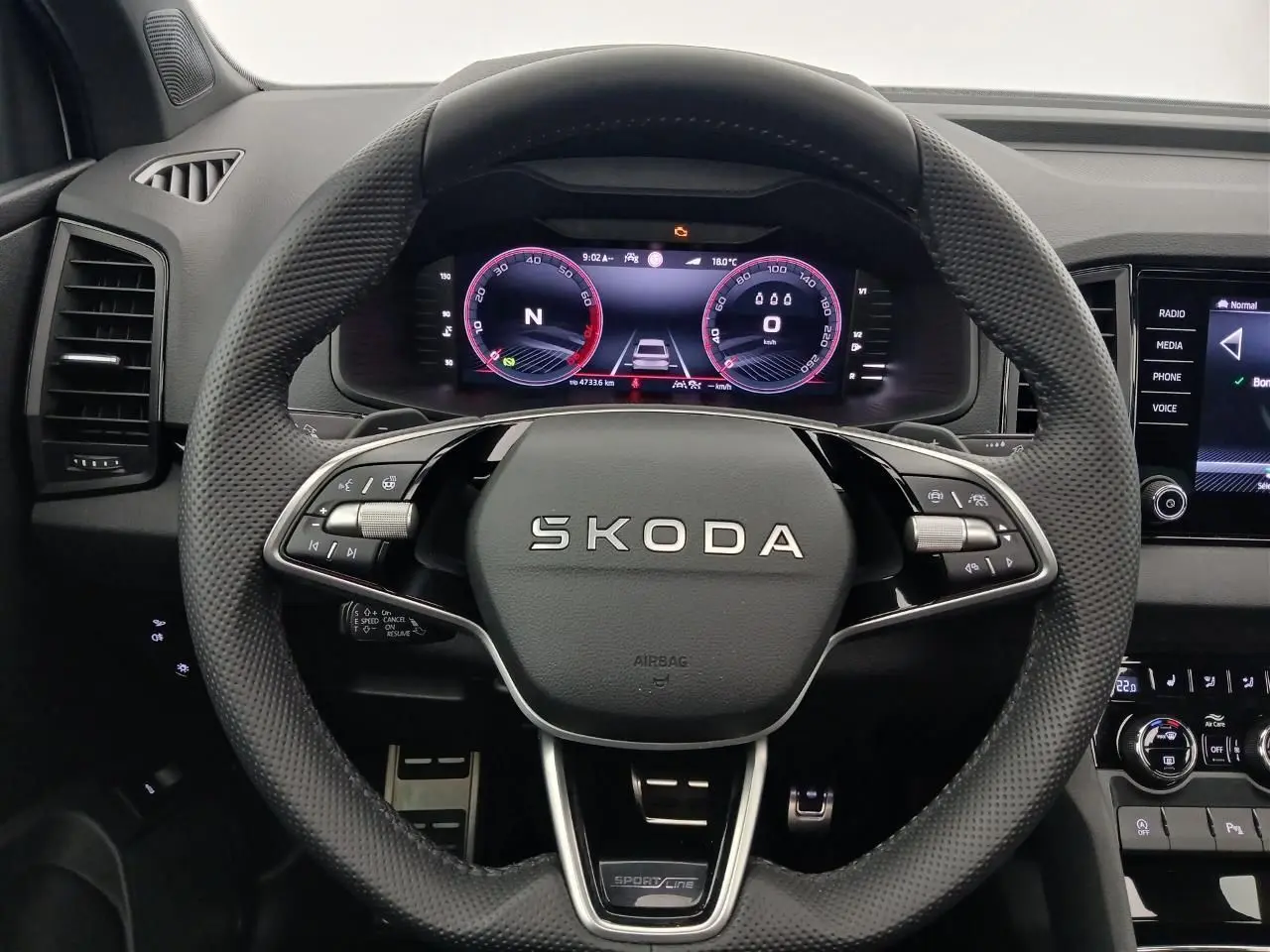 Vue rapprochée du volant SKODA KAROQ 1.5 TSI 150 DSG7 Sportline avec tableau de bord numérique et commandes intégrées.