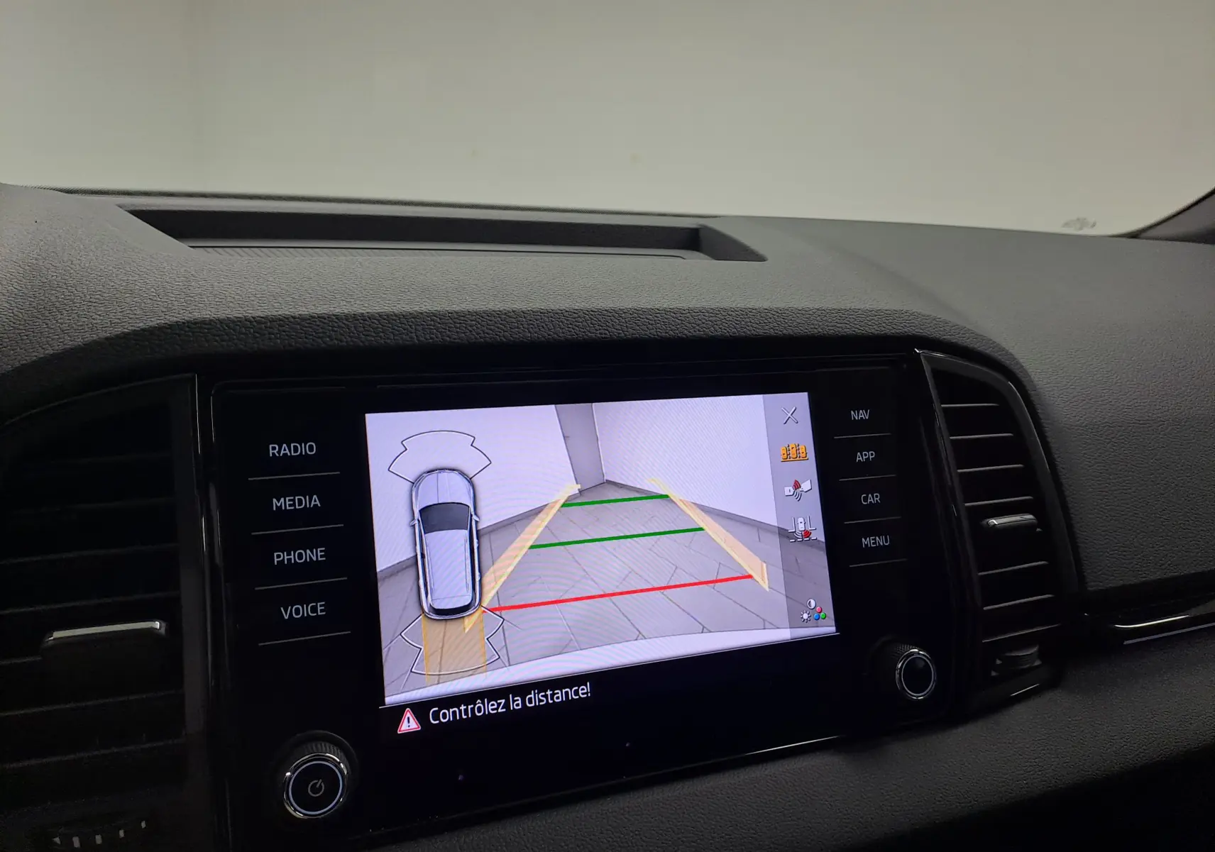 Écran multimédia du Skoda Karoq blanc lune 2025 montrant la caméra de recul avec guidage de trajectoire.