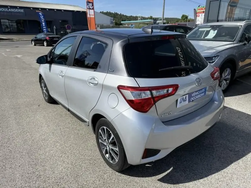 Vue 3/4 arrière droite d'une Toyota Yaris 2020 gris métal avec toit foncé et vitres teintées, garée en extérieur.