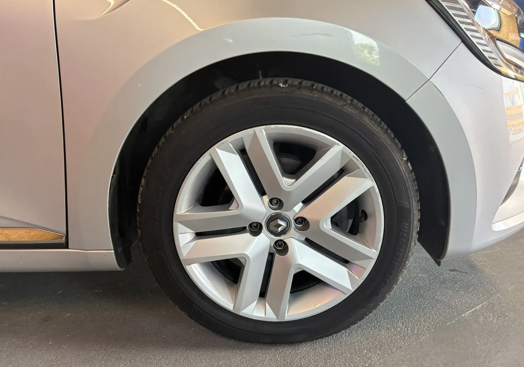 Gros plan sur la roue avant gauche de la Renault Clio 1.5 BlueDCI Business gris 2022 avec jante alliage distinctive.