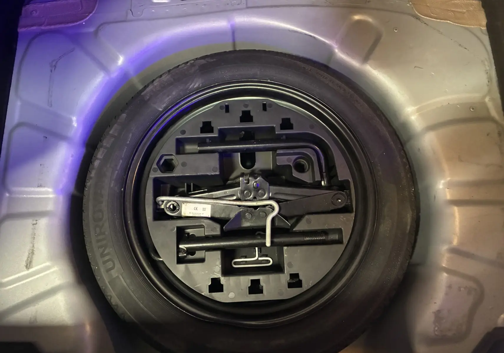 Gros plan sur la roue de secours et les outils de bord dans le coffre d'une Renault Clio 1.5 BlueDCI Business gris 2022.