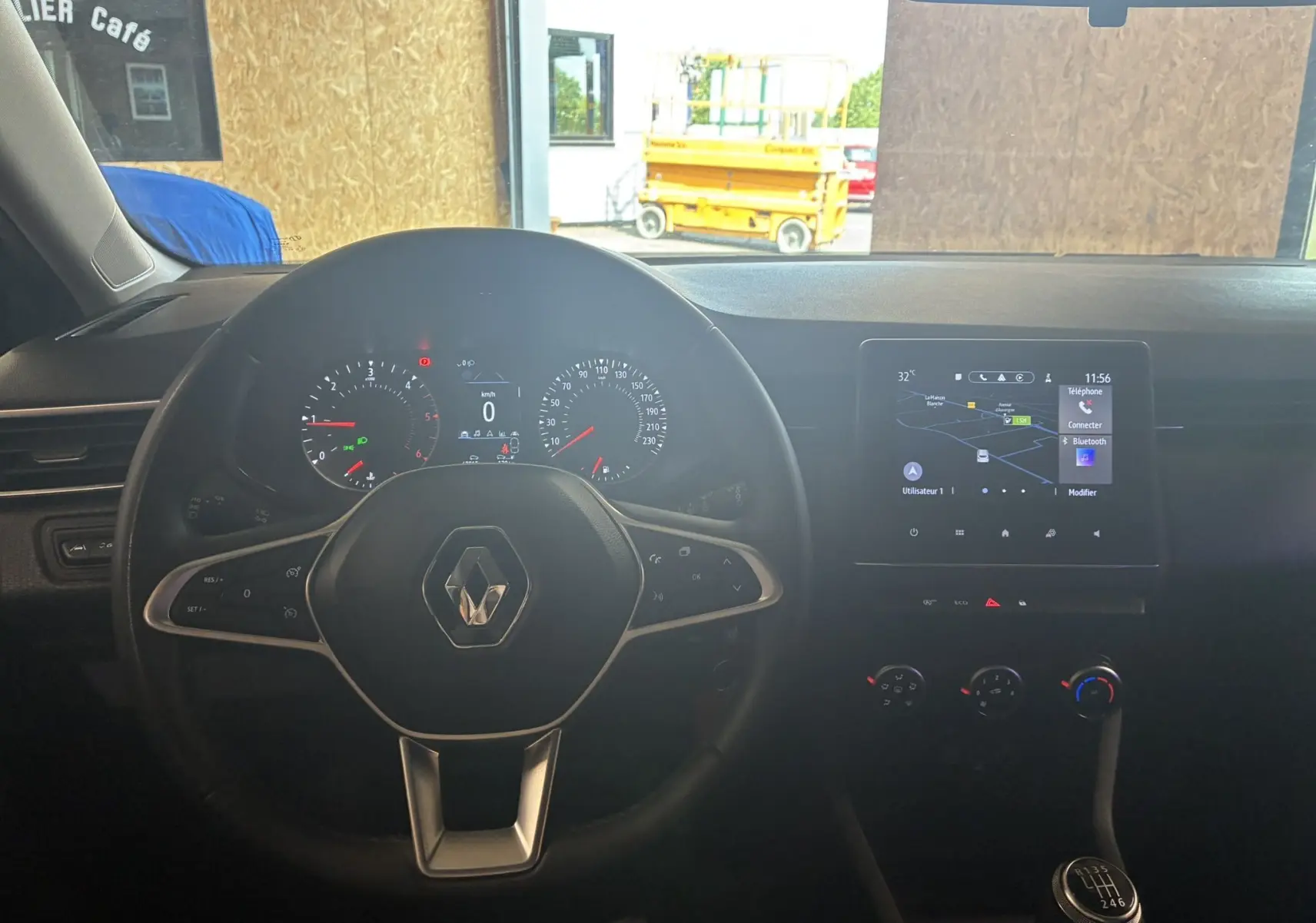 Vue intérieure du tableau de bord de la Renault Clio 1.5 BlueDCI Business 2022 avec volant multifonction et écran tactile GPS.