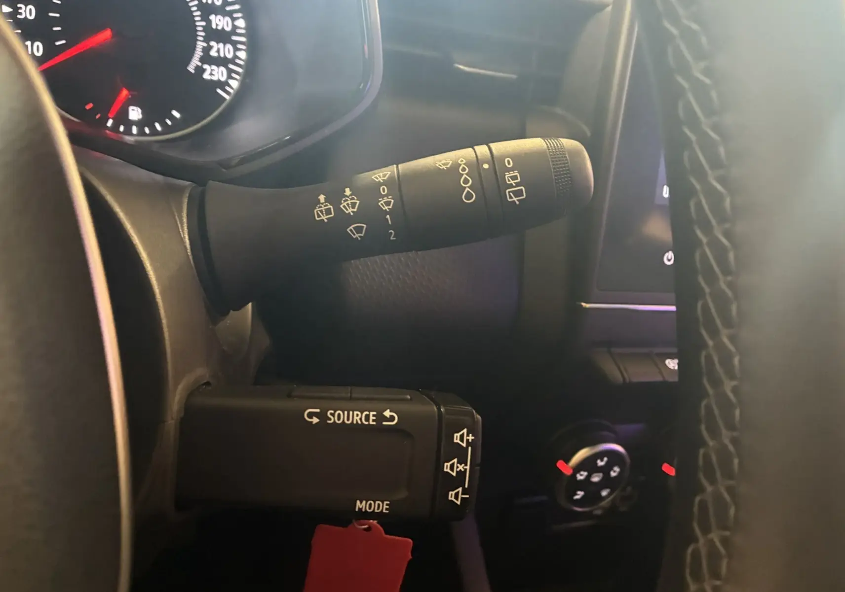 Gros plan sur les commandes au volant d'une Renault Clio 1.5 Blue dCi Business 2022, intérieur noir et tableau de bord partiel.