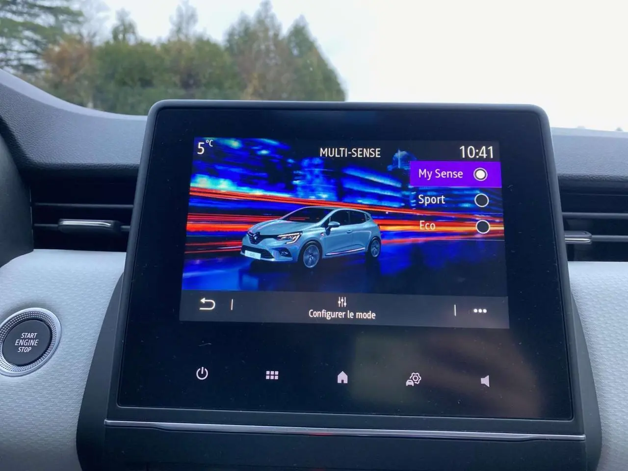 Écran tactile central affichant les modes de conduite avec illustration d'une Renault Clio blanche en 3/4 avant.