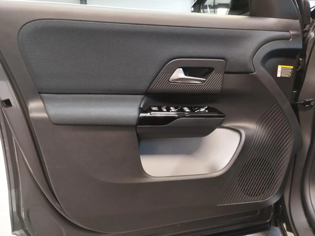 Vue rapprochée de la porte avant droite gris platine du Citroën C5 Aircross 2026 avec commandes et haut-parleur intégrés.