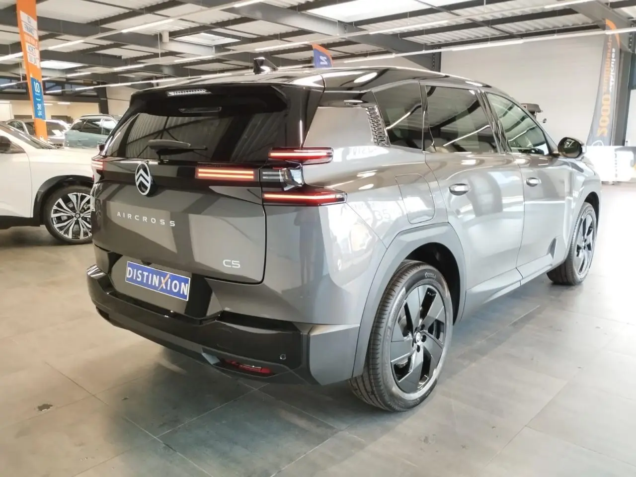 Vue 3/4 arrière droite du Citroën C5 Aircross gris platine avec toit noir et feux arrière LED distinctifs.