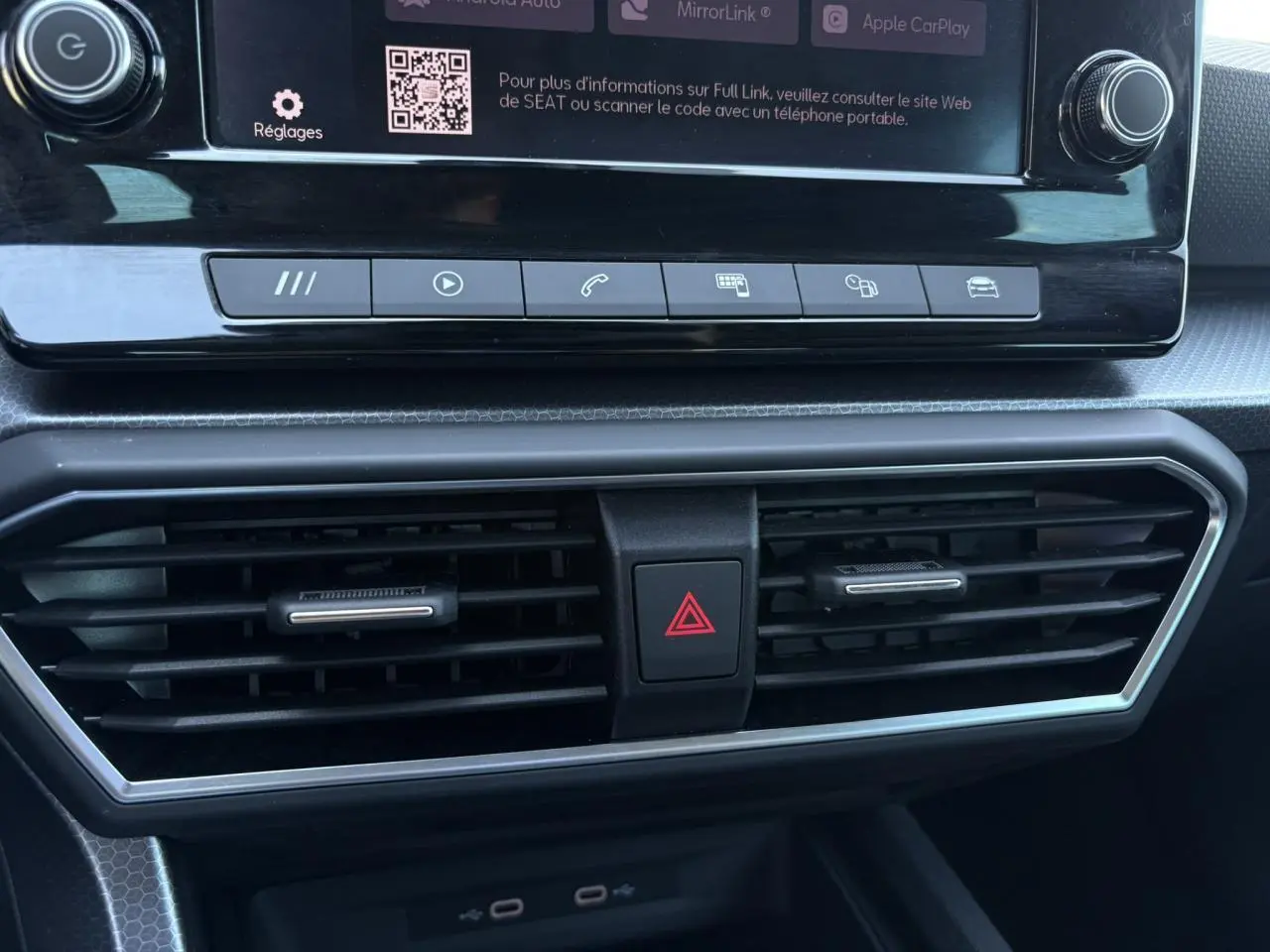Détail du tableau de bord de la SEAT Leon 2024, montrant les aérateurs centraux et les commandes multimédia.