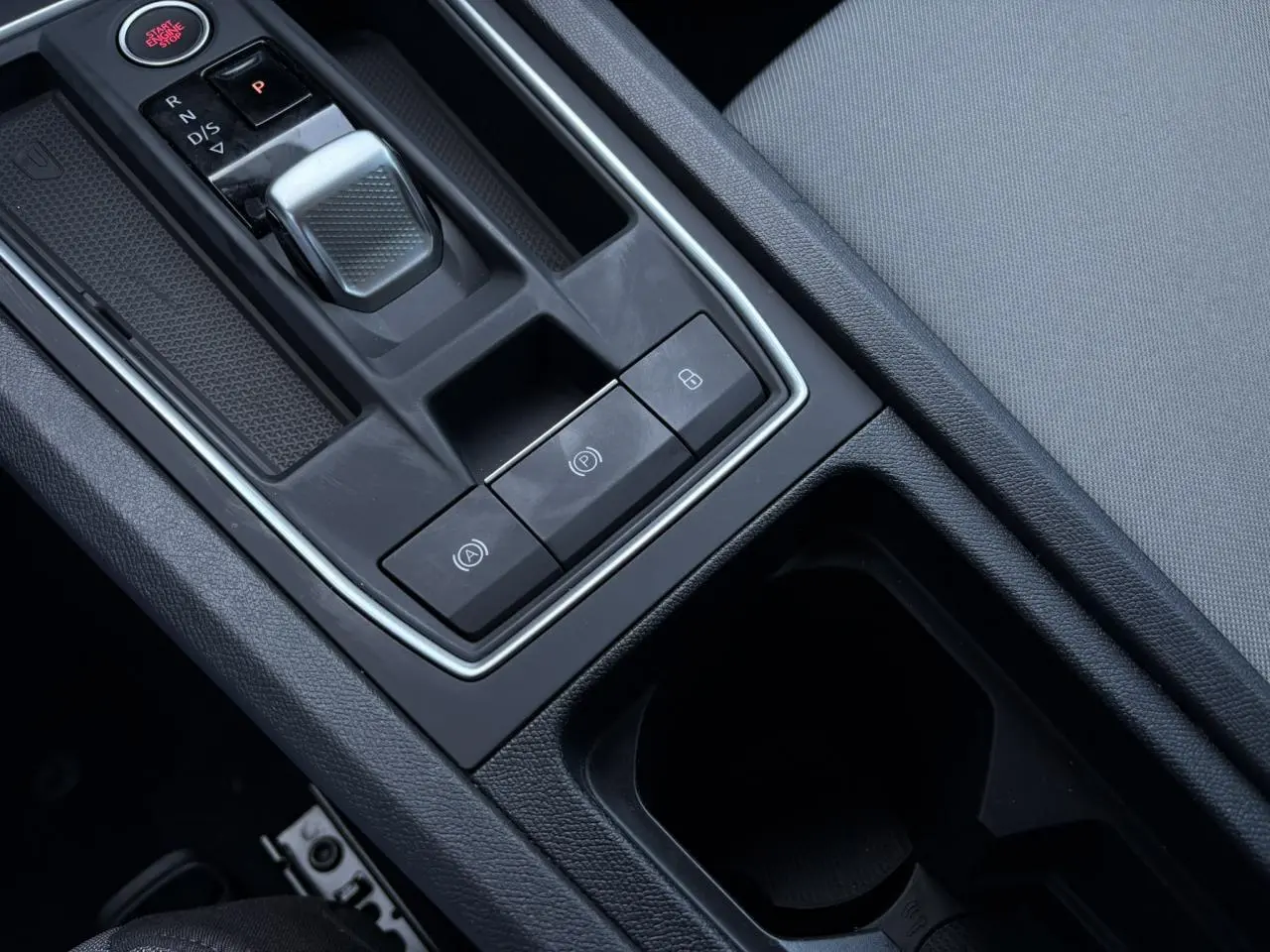 Gros plan sur la console centrale du SEAT LEON 2024 gris argent, mettant en valeur la boîte auto et les commandes électroniques.