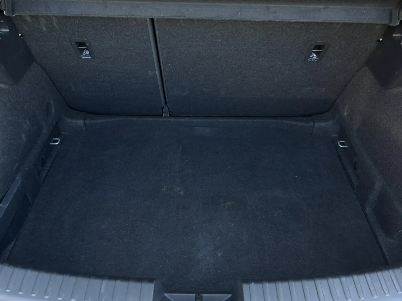 Vue plongeante sur le coffre spacieux et tapissé de noir du SEAT LEON 2.0 TDI 150 DSG Style gris argent 2024.