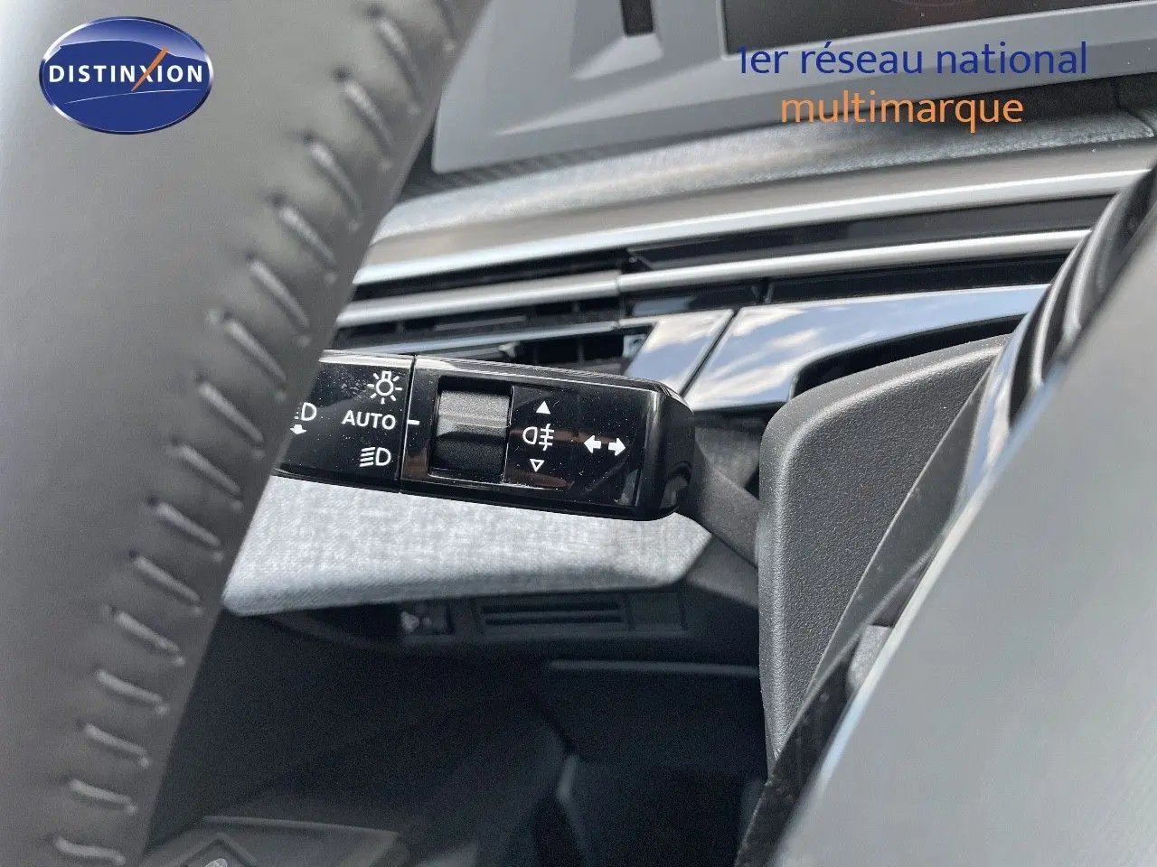 Gros plan sur la commande des feux et clignotants à gauche du volant dans l'habitacle du Peugeot 3008 Hybrid bleu.