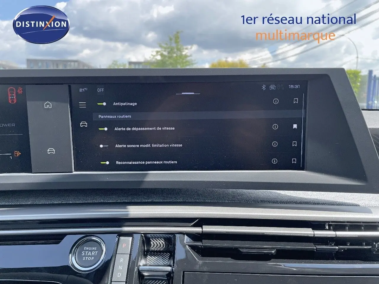 Vue rapprochée de l'écran tactile et console centrale du Peugeot 3008 Hybrid 2025 avec commandes modernes et finition noire brillante.