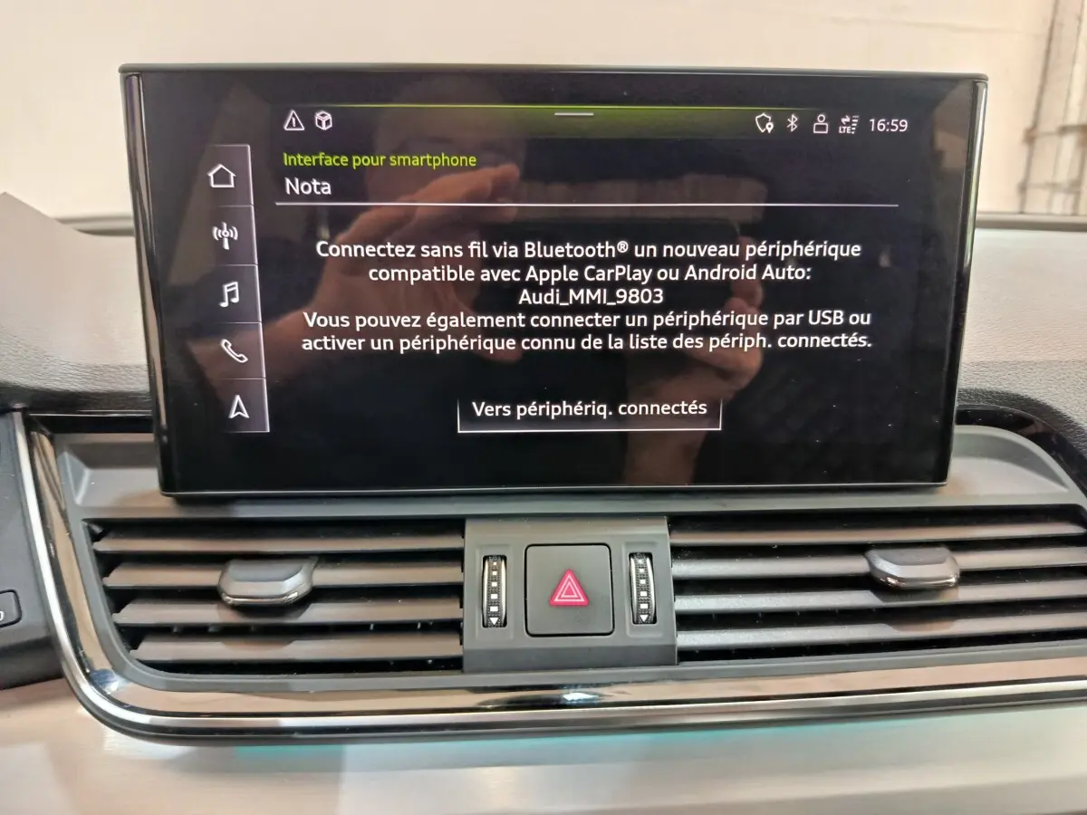 Écran central tactile affichant l'interface smartphone dans l'habitacle d'un Audi Q5 gris clair 2023 hybride rechargeable.