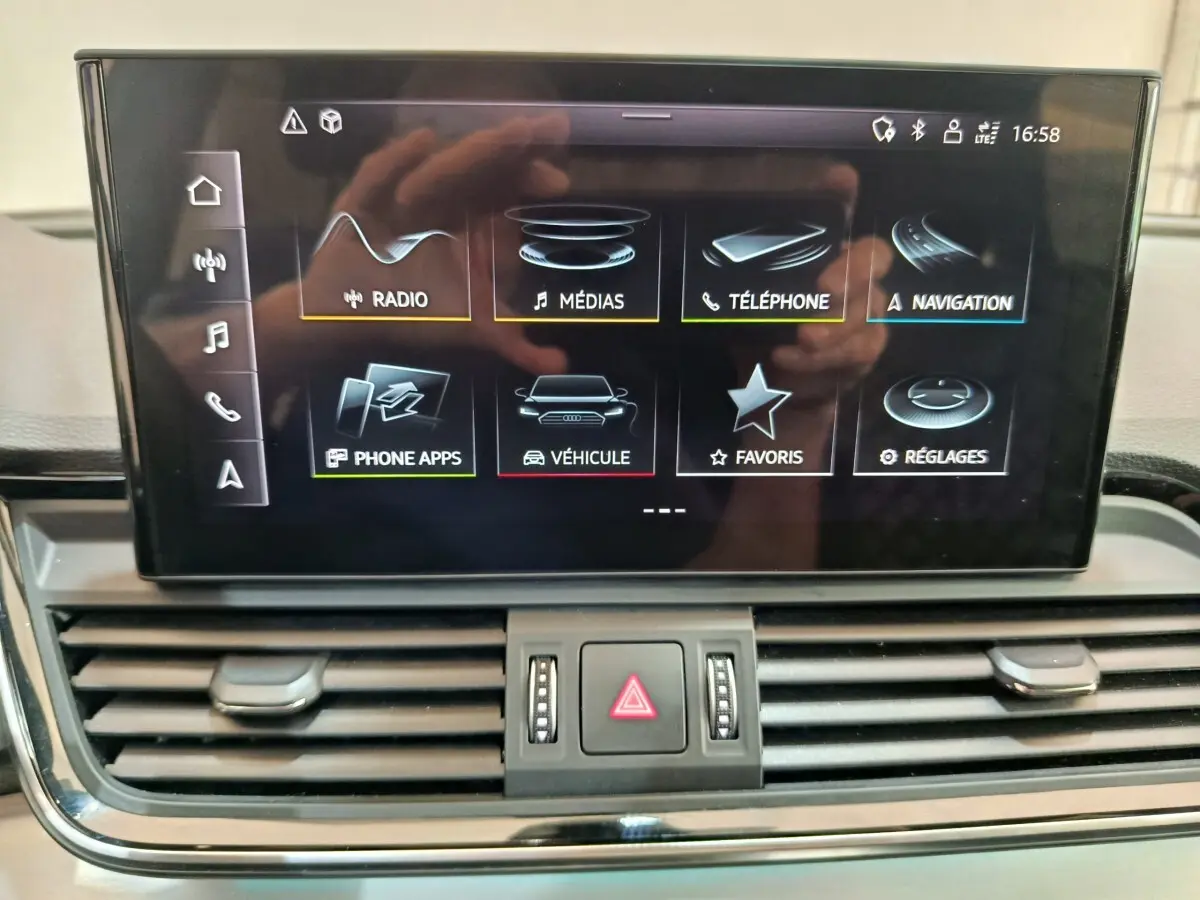 Écran central tactile de l'Audi Q5 2023 gris clair affichant le menu multimédia et navigation.