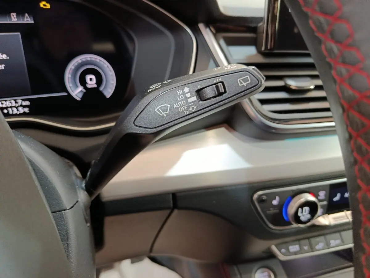 Gros plan sur la commande d’essuie-glace à gauche du volant dans l’Audi Q5 gris clair hybride rechargeable 2023.