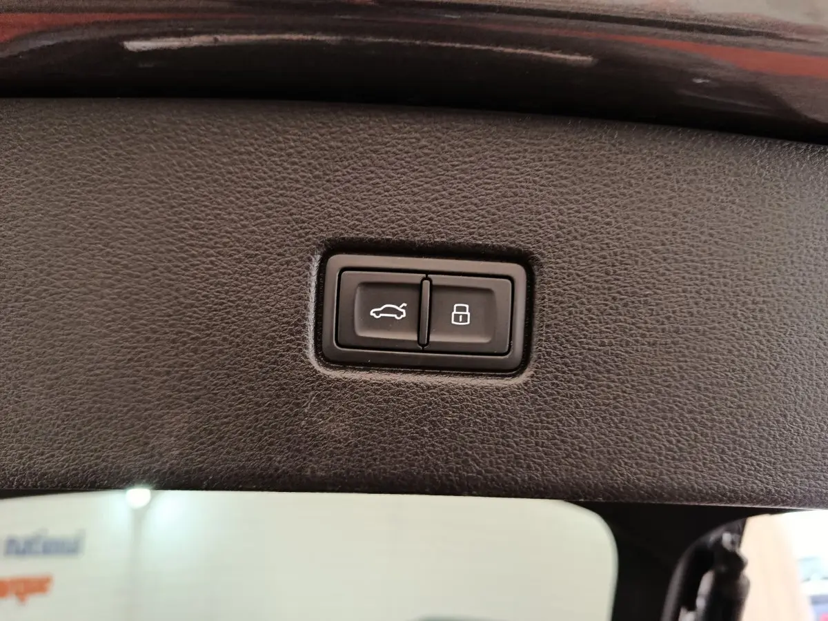 Boutons d'ouverture de coffre et de verrouillage intégrés dans le panneau intérieur du hayon d'un Audi Q5 gris clair 2023 hybride rechargeable.