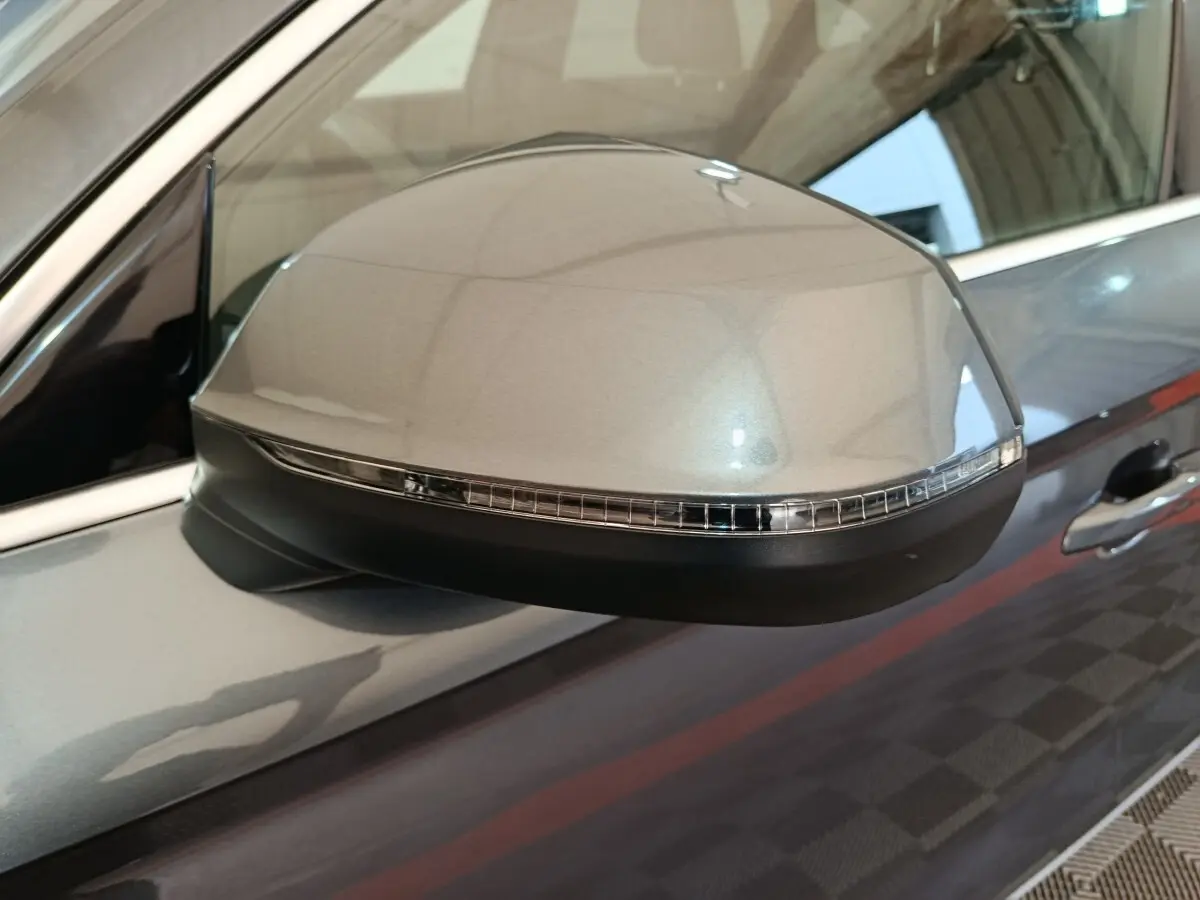 Gros plan sur le rétroviseur côté gauche gris clair de l'Audi Q5 2023 hybride rechargeable avec clignotant intégré.