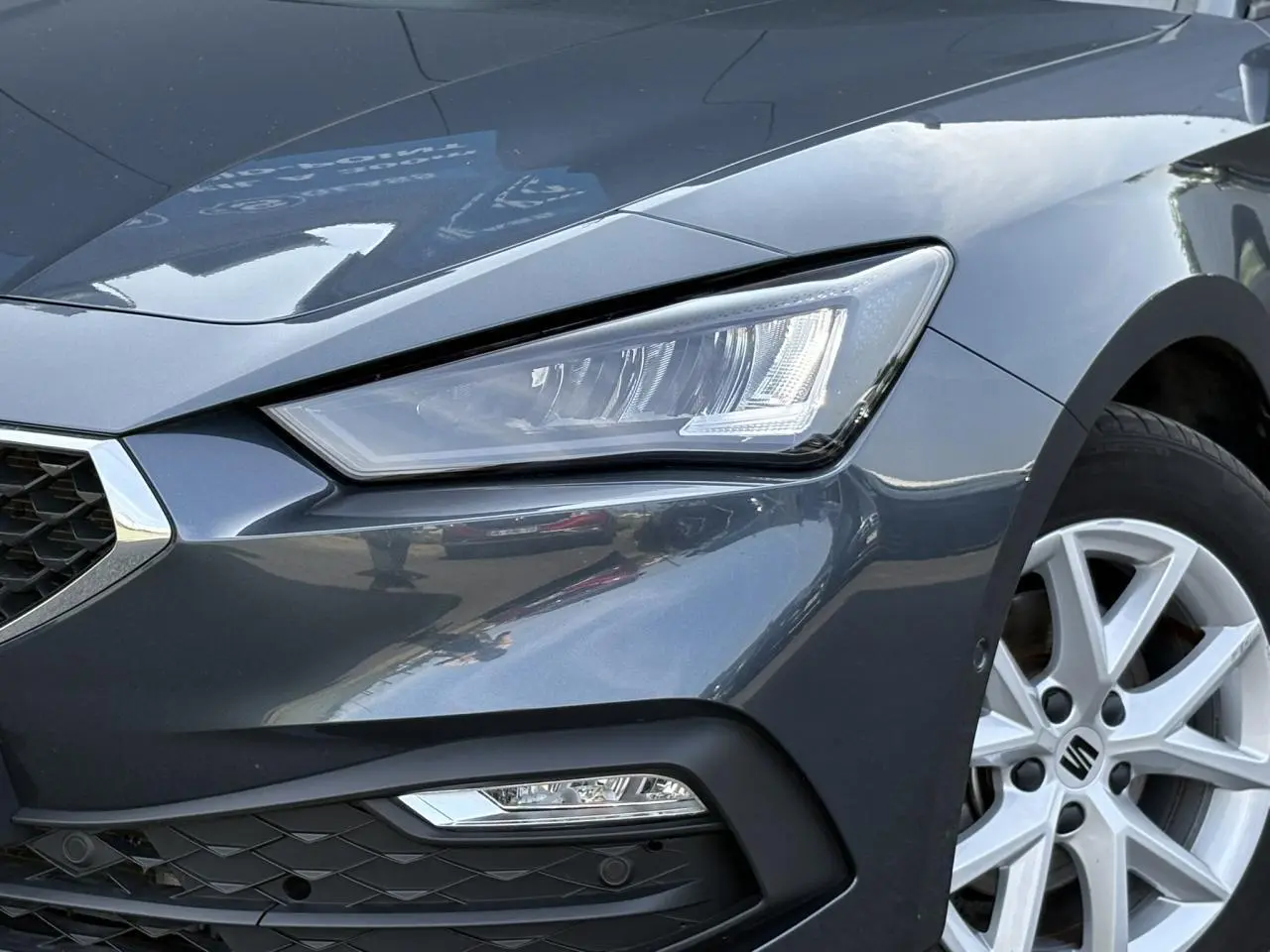 Gros plan sur l'avant droit gris magnétique du SEAT LEON 2024, mettant en valeur le phare LED et la jante alliage 16 pouces.